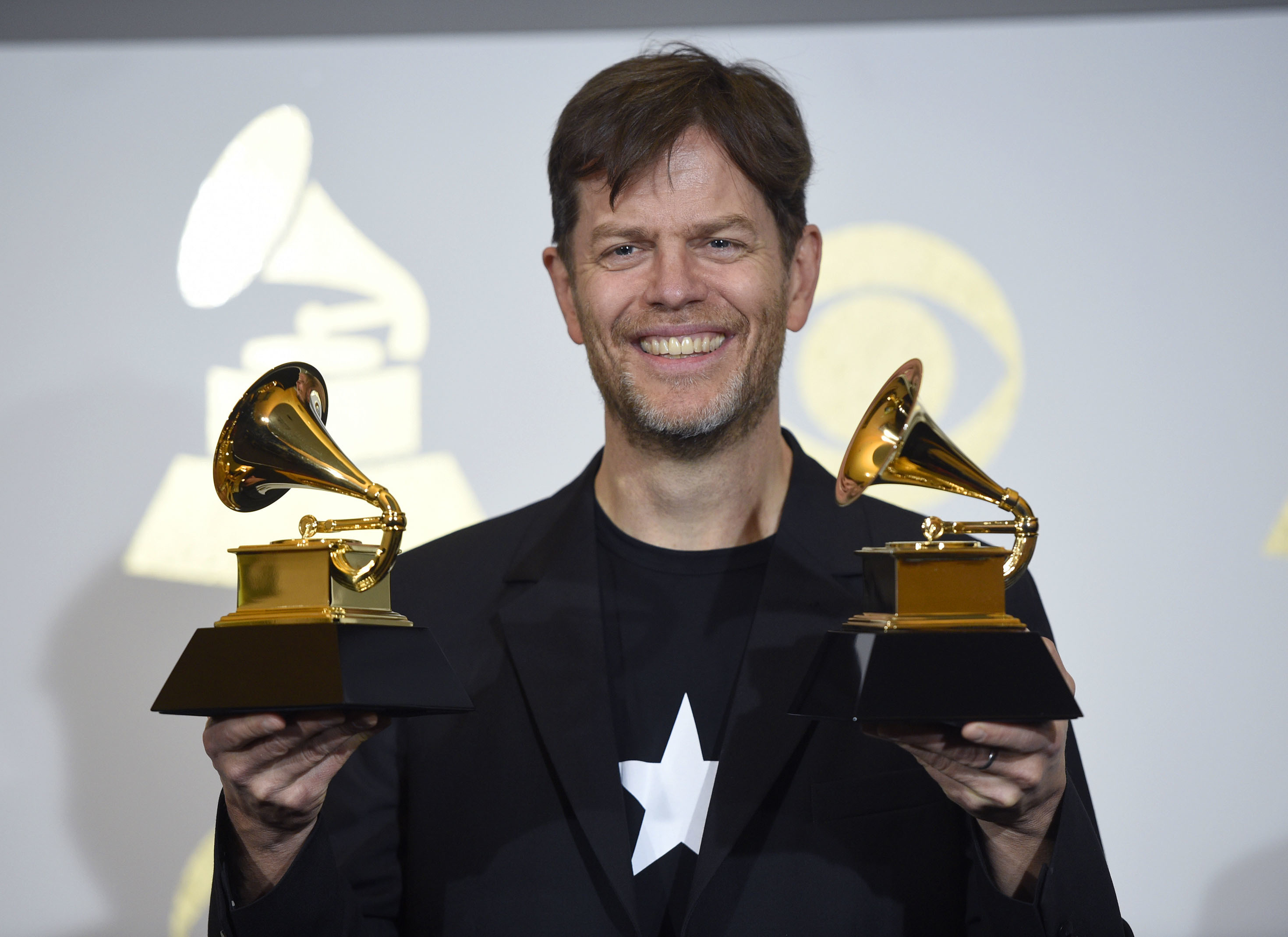 Donny McCaslin poses in the press room with the awards for best alternative music album and best rock performance for Blackstar at the 59th annual Grammy Awards at the Staples Center in Los Angeles- AP